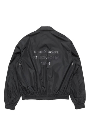 Acne Studios logo-print zip jacket. Features the 1996 logo across the back, recycled nylon with a relaxed fit.  Available at our Lisbon store.