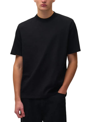 Person wearing a plain black short-sleeve t-shirt and black pants