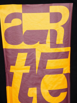 T-shirt with large 'arte' purple letters on a yellow background.