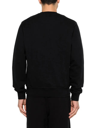 Person wearing a black sweatshirt with black pants