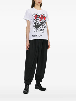 Black Comme Des Garçons x Nike white logo-print T-shirt with crew neck and short sleeves — available at our Lisbon store.