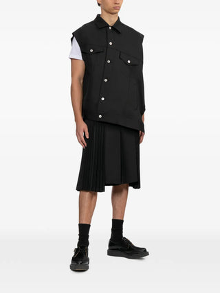 Black Comme des Garçons asymmetric-hem vest in black with chest pockets — avant-garde layering piece, available at our Lisbon store.