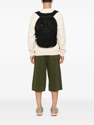 C.P. Company black Nylon B backpack with quilted back panel, lens detail and zip fastening. A practical essential, available at our Lisbon store.