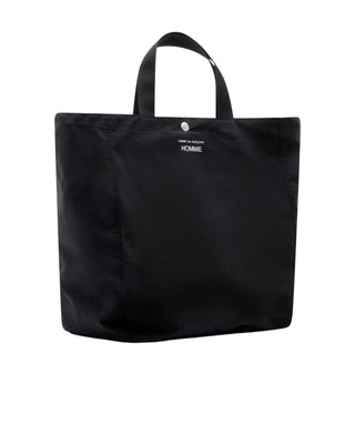 A minimalist nylon shopper from COMME DES GARÇONS HOMME. Features a roomy main compartment and two durable handles. Available at our Lisbon store. 