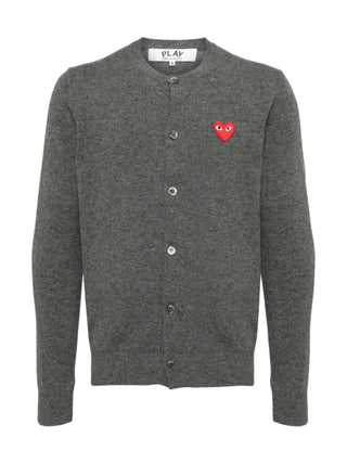 The cardigan by Comme des Garçons. Key details include, front button fastening, long sleeves, and round (crew) neck with the distictive heart patch logo