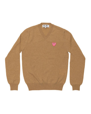Comme Des Garçons PLAY pink emblem knit in light brown. A signature heart patch V-neck pullover crafted from 100% wool. Available at our Lisbon store.