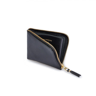 CDG zip-around leather wallet. Smooth leather, gold-tone zipper, and a compact interior with card slots, a bill compartment, and a coin pocket.