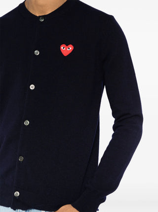 PLAY cardigan by Comme des Garçons featuring iconic heart motif. Pure wool knit in a classic silhouette. Button-front with ribbed trims and signature patch.
