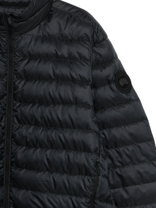 Close-up of a black puffer jacket with a brand logo by Canada Goose