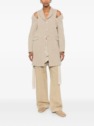 Comme des Garçons beige textured coat with cut-out detailing and frayed edges, available at our Lisbon store.