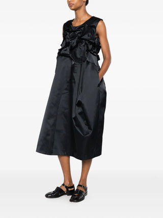Comme des Garçons black satin dress with ruffled detail and flared hem, available at our Lisbon store.