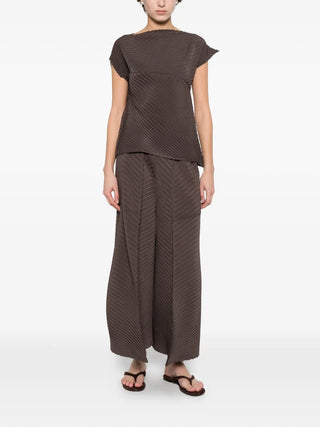 Issey Miyake brown pleated sleeveless top with flexible fit. Modern sculptural style, available at our Lisbon store.
