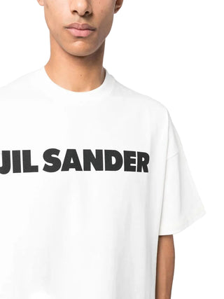 Person wearing a white t-shirt with 'Jil Sander' logo