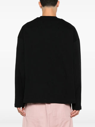 Person wearing a black sweater and light pink pants