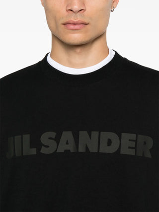Black sweater with 'Jil Sander' logo worn by a person 