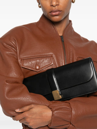 KHAITE Blake clutch bag in black smooth leather with foldover top and gold-tone hardware. Minimal and refined. Available at our Lisbon store.