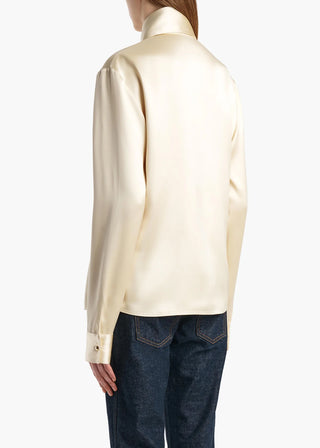 Ivy Top by KHAITE. Sculptural high neck and fluid drape in double-faced satin. A refined, long silhouette. Available at our Lisbon store. 