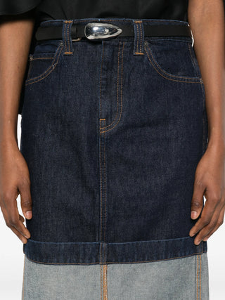 Person wearing Khaite Kilian denim skirt with a Black belt and silver buckle