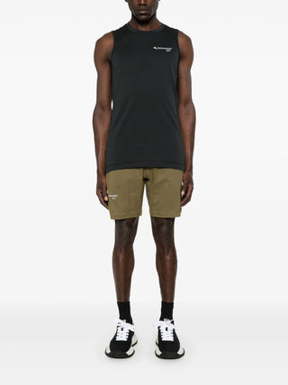 Person wearing a black sleeveless shirt and khaki shorts by Klättermusen 