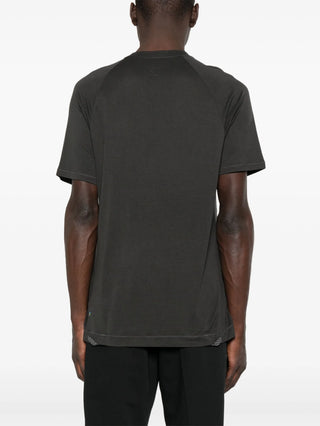 Person wearing a dark grey t-shirt by Klattermusen