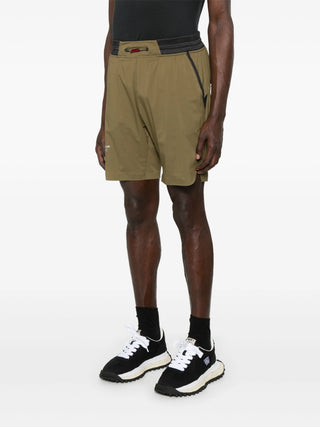 Person wearing khaki athletic shorts with a Black top and Black sneakers
