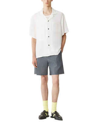 Person wearing a white shirt and gray shortsby Lanvin