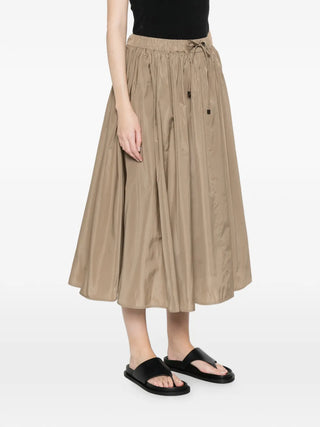 The Lonza midi skirt in silk-blend taffeta, elasticated waist for comfort and a flared A-line for movement. Available at our Lisbon store.