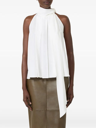 MAX MARA pussy-bow top. Sleeveless silk design with a feminine bow. Italian craftsmanship redefined. Available at our Lisbon store.