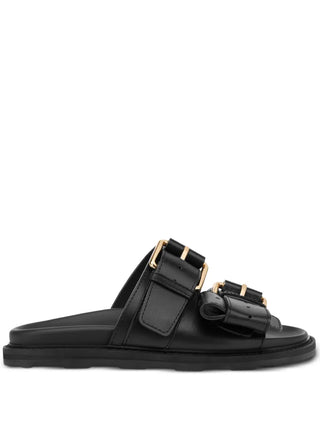 Moschino double-strap sandals crafted from 100% calf leather. Features a flatform silhouette, gold-tone buckles, and a chunky rubber sole. 