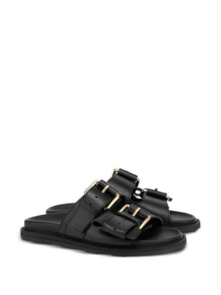 Moschino double-strap sandals crafted from 100% calf leather. Features a flatform silhouette, gold-tone buckles, and a chunky rubber sole. 