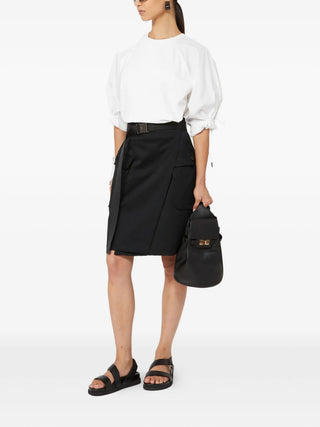Max Mara white ruffled‑sleeve top with side slits and logo patch. Simple elegance. Available at our Lisbon store.