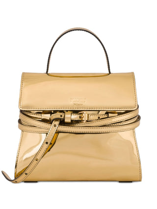 Moschino gold-tone Tie Me tote with top handle, buckle detail, and protective dust bag. A compact statement bag, available at our Lisbon store.