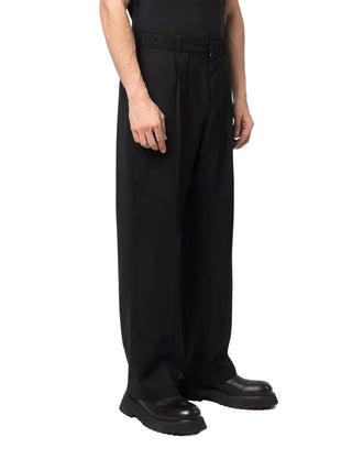 Crafted from virgin wool, these trousers feature a straight-leg with sharp pleats and finished with a zip fly, horn button detailing and side pockets.