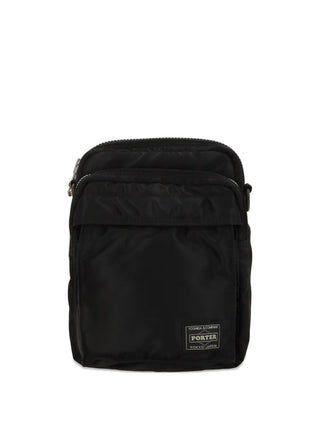 PORTER Tanker Vertical Bag in black with zip fastening, front pocket and adjustable strap for everyday wear, available at our Lisbon store.