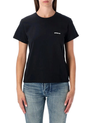 Person wearing a black t-shirt with a logo and blue jeans by Patagonia