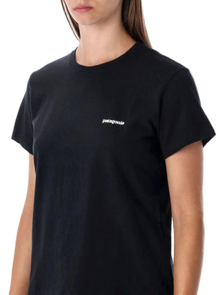 Person wearing a black t-shirt with a white logo
