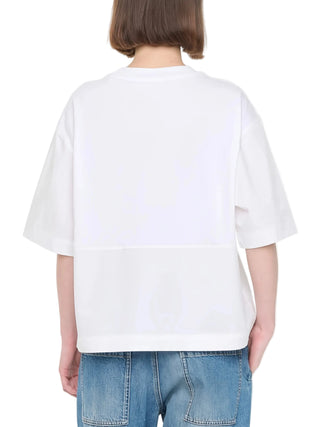 Person wearing a white t-shirt and blue jeans by Plan C.