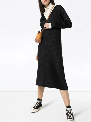Pleats Please Issey Miyake black pleated mid-length dress with V-neck and long sleeves, easy shift fit, available at our Lisbon store.