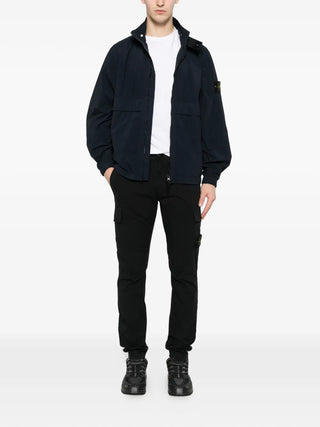Stone Island logo-patch cargo pants in stretch cotton. A tapered fit with elasticated cuffs and  iconic removable compass badge. Available at our Lisbon store.