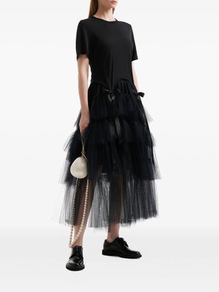 Simone Rocha black tiered ribbon midi skirt with tulle overlay and elegant detailing. A refined piece available at our Lisbon store.