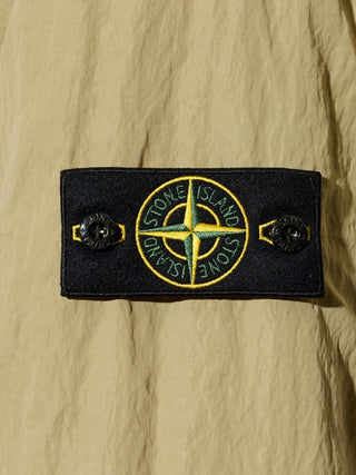 Stone Island hooded jacket with signature Compass patch. Functional hood, zip fastening, and technical fabric. Available at our Lisbon store. 