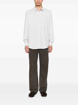 The Row Pace shirt. A classic button-up featuring a patch pocket, mother-of-pearl buttons, and a curved hem. Available at our Lisbon store. 