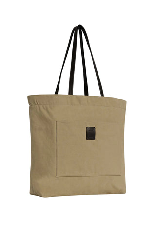 Tori canvas tote bag by THE ROW. Minimal silhouette, leather trim, front slot pocket, and button closure.  Available at our Lisbon store.