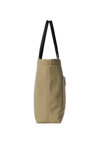 Tori canvas tote bag by THE ROW. Minimal silhouette, leather trim, front slot pocket, and button closure.  Available at our Lisbon store.