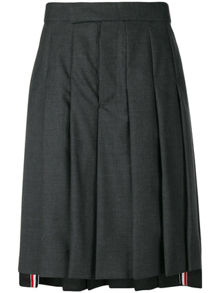 Thom Browne Classic Rise Backstrap skirt. A pleated knee-length silhouette in Super 120s wool with an adjustable backstrap and signature striped grosgrain trim.