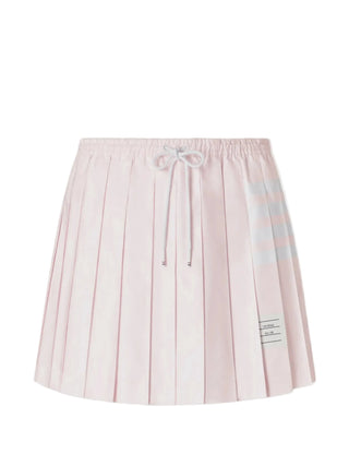 Thom Browne drawstring pleated mini. Iconic 4-Bar stripe, elasticated waist, and Italian craftsmanship. An iconic silhouette, available at our Lisbon store. 