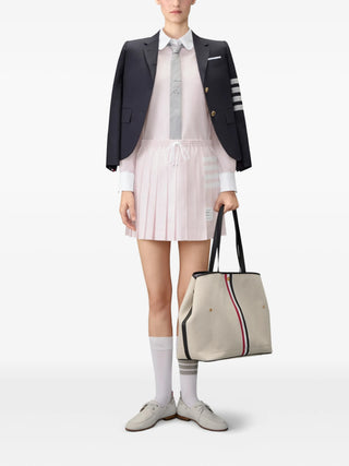 Thom Browne drawstring pleated mini. Iconic 4-Bar stripe, elasticated waist, and Italian craftsmanship. An iconic silhouette, available at our Lisbon store. 