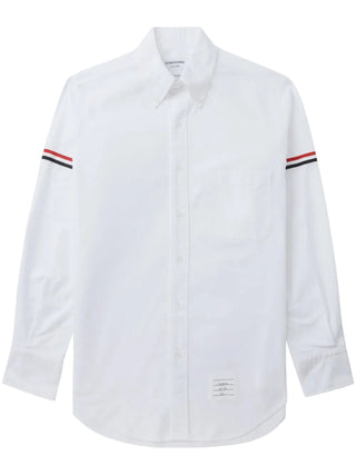 Cut from crisp white cotton, this long-sleeve shirt from Thom Browne features the iconic RWB stripe across the arms. Available at our Lisbon store. 
