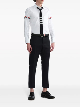 Cut from crisp white cotton, this long-sleeve shirt from Thom Browne features the iconic RWB stripe across the arms. Available at our Lisbon store. 