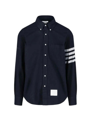THOM BROWNE straight fit shirt. Oxford or chambray with signature 4-Bar stripe, patch pocket, and name tag patch. Available at our Lisbon store. 